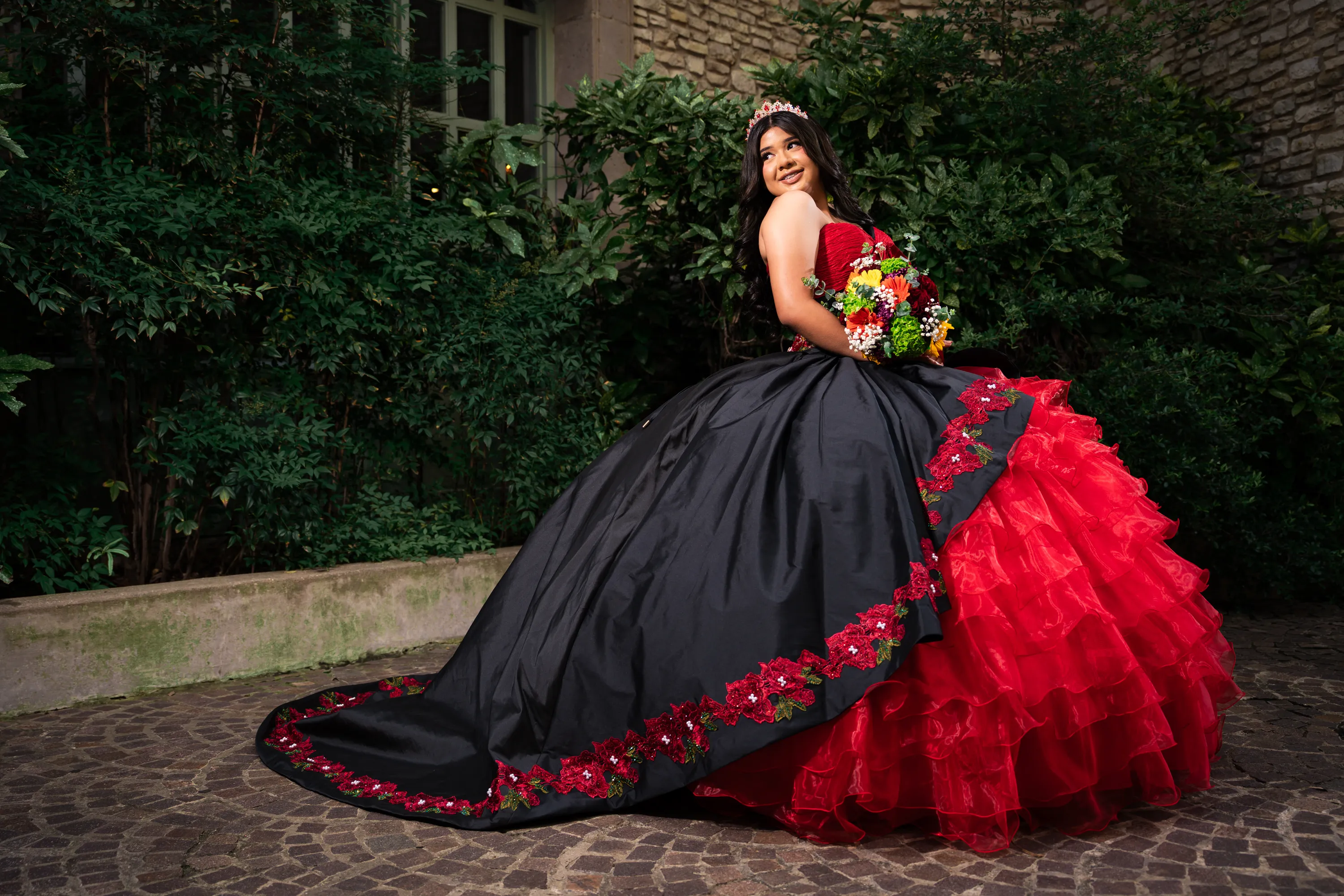 Quinceañera con vestido charro negro y rojo bordado con rosas en el Mandalay Canal de Irving, Texas
