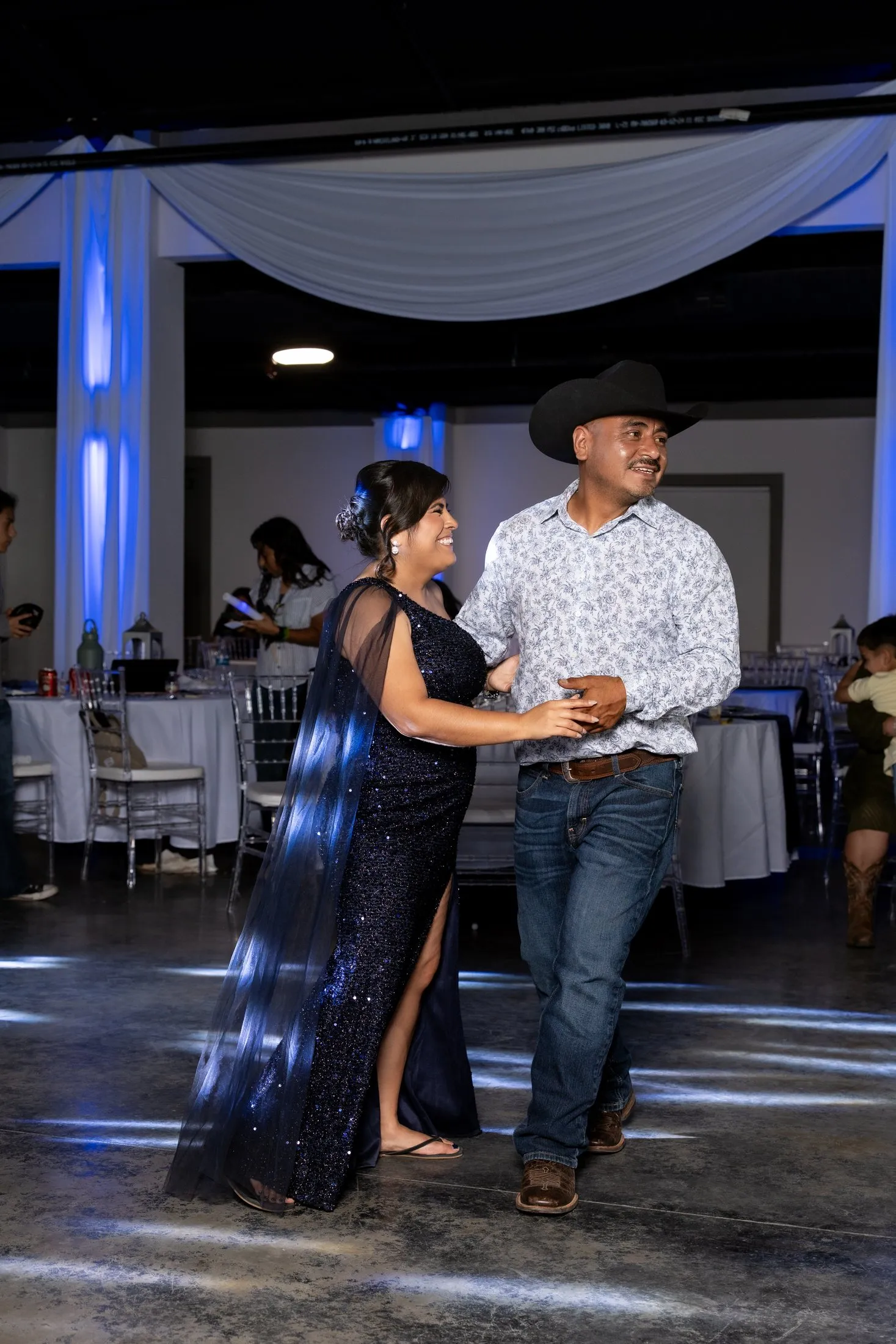 Couple dancing on the quince dance floor under blue lights