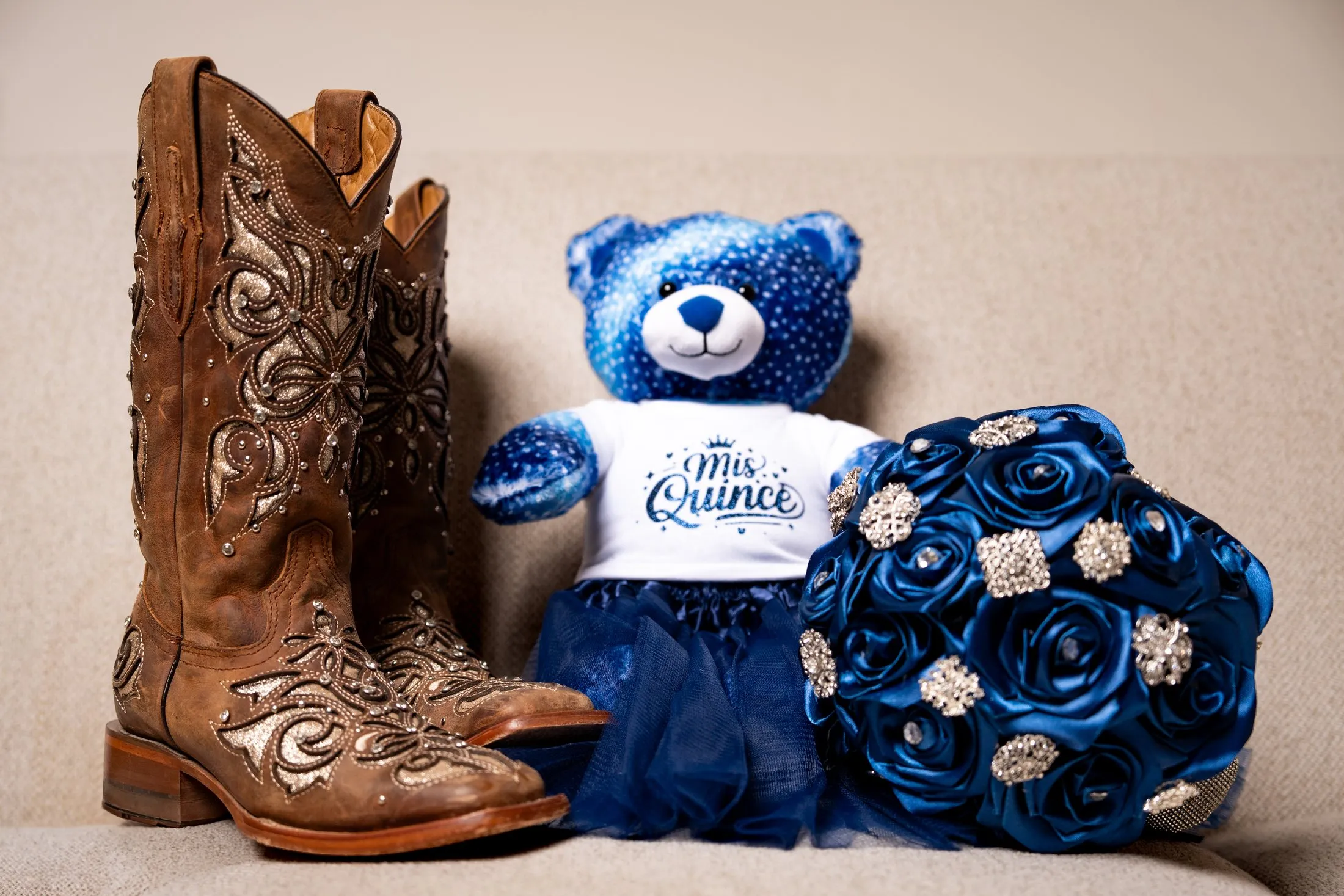 Embroidered cowgirl boots, a Mis Quince teddy bear and a navy rose bouquet