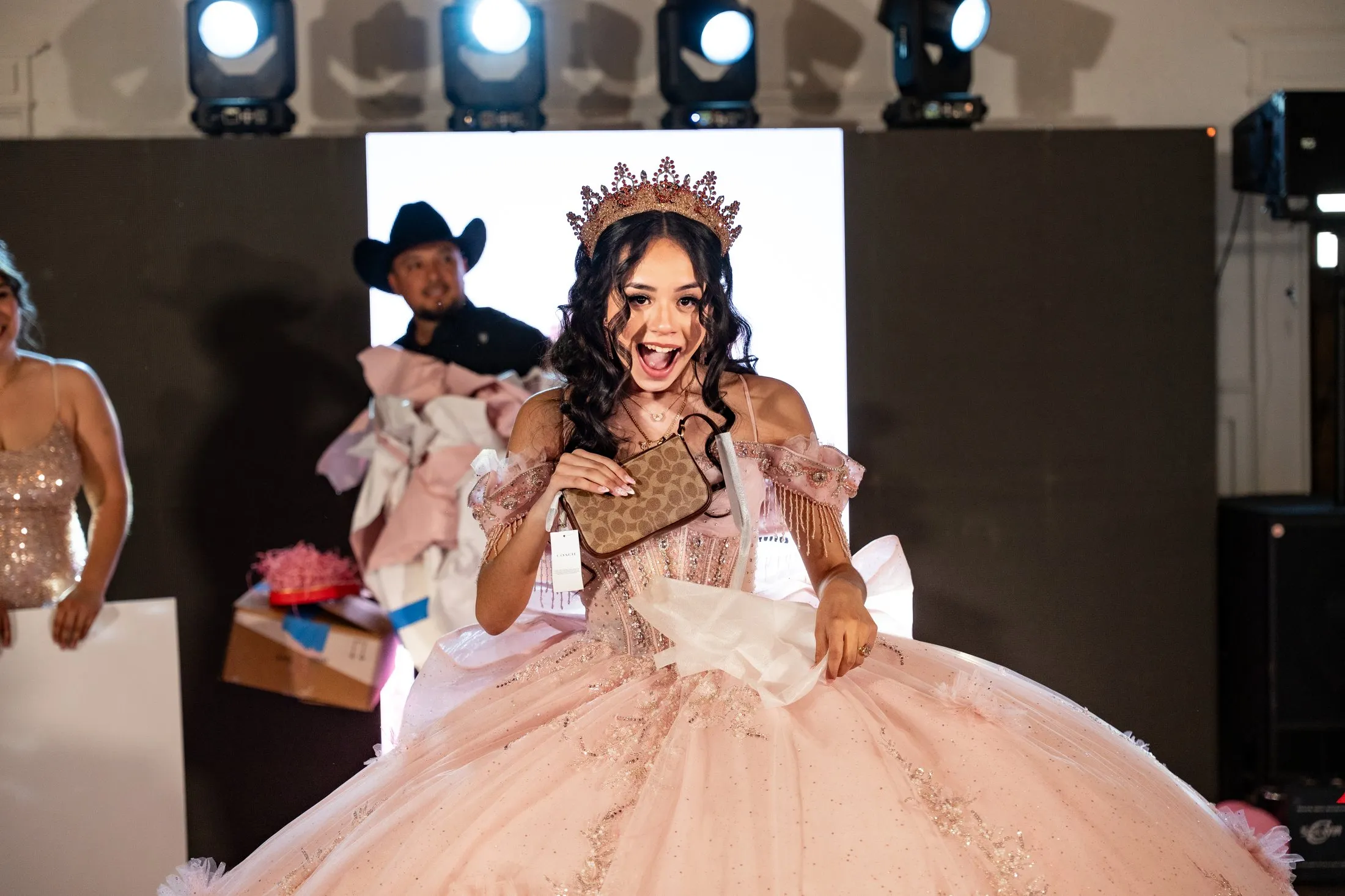 Excited quinceañera opening a gift at Hidden Acres Ranch in Hudson Oaks