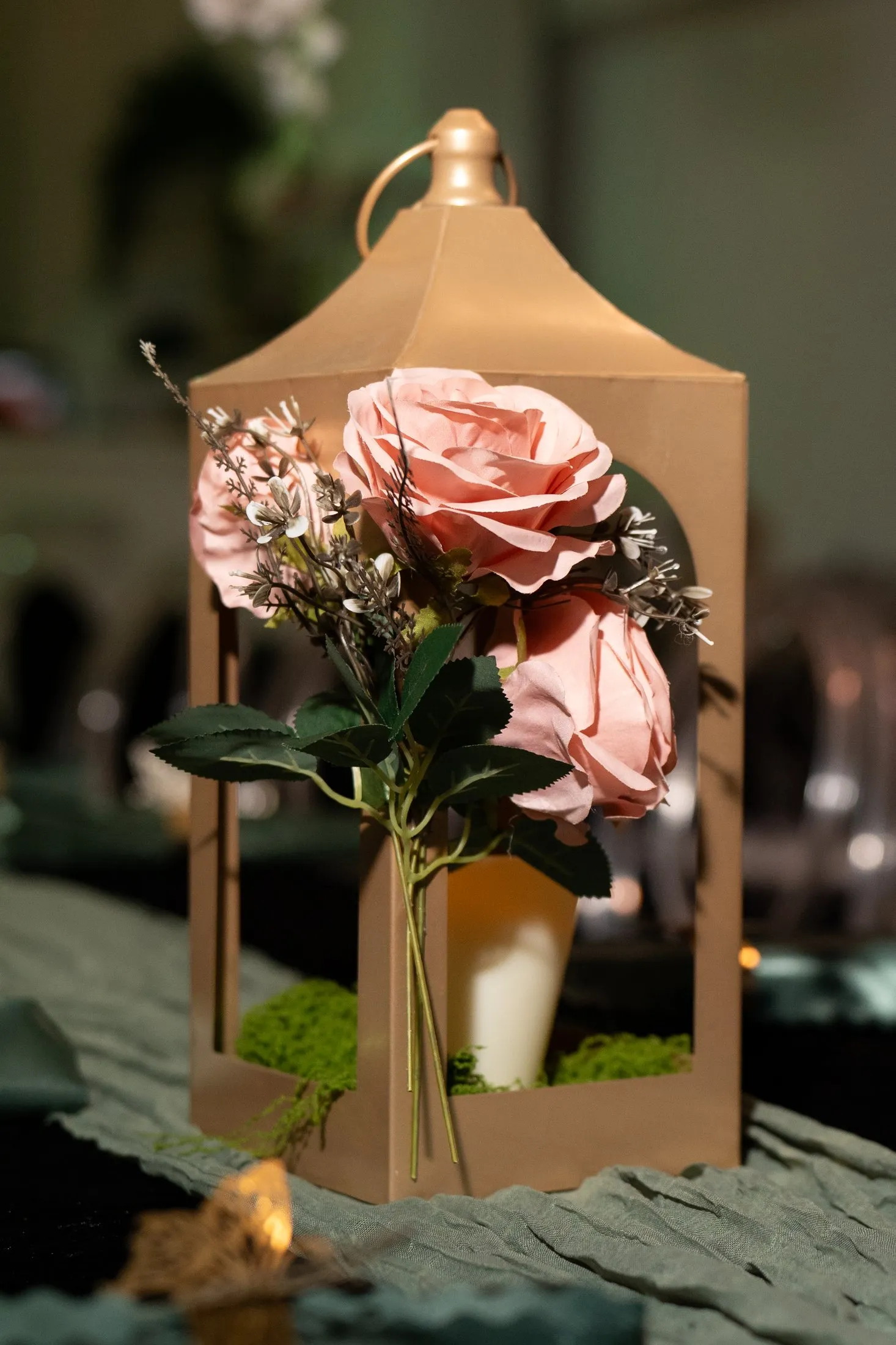 Gold lantern with pink roses on the reception tables