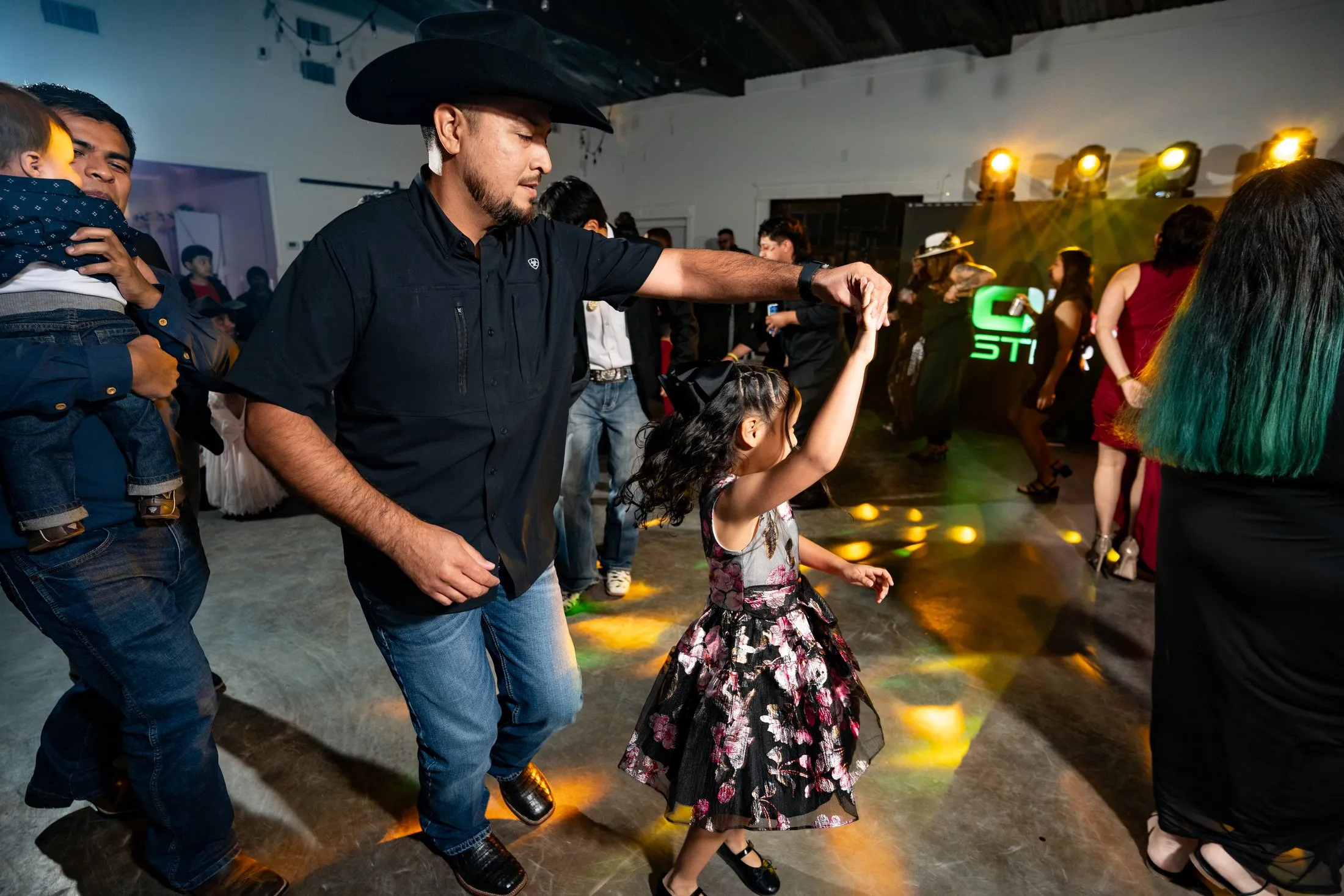 Guest in a cowboy hat dancing with a little girl at Hidden Acres Ranch in Hudson Oaks