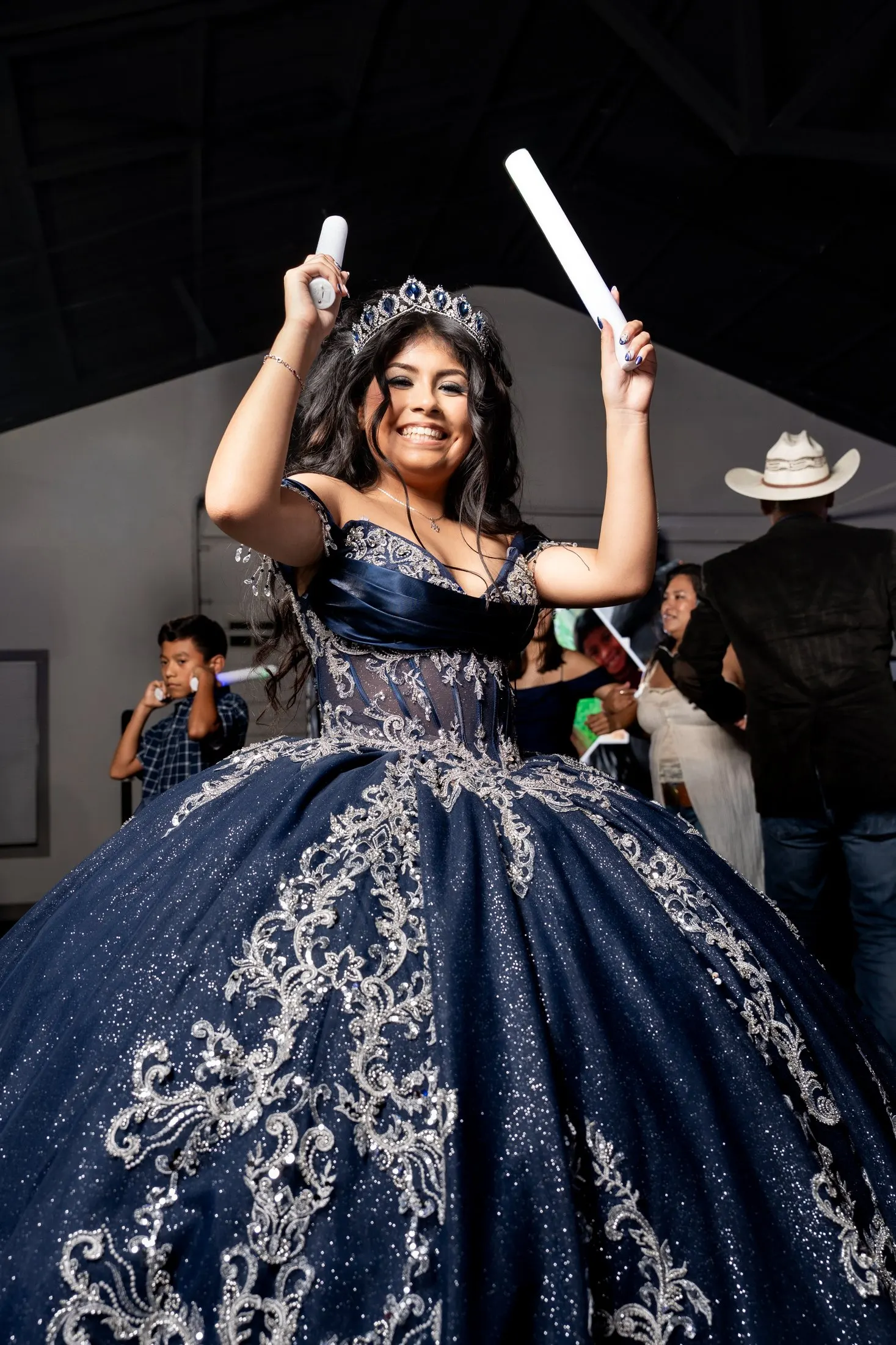 Joyful quinceañera dancing in her navy quince gown