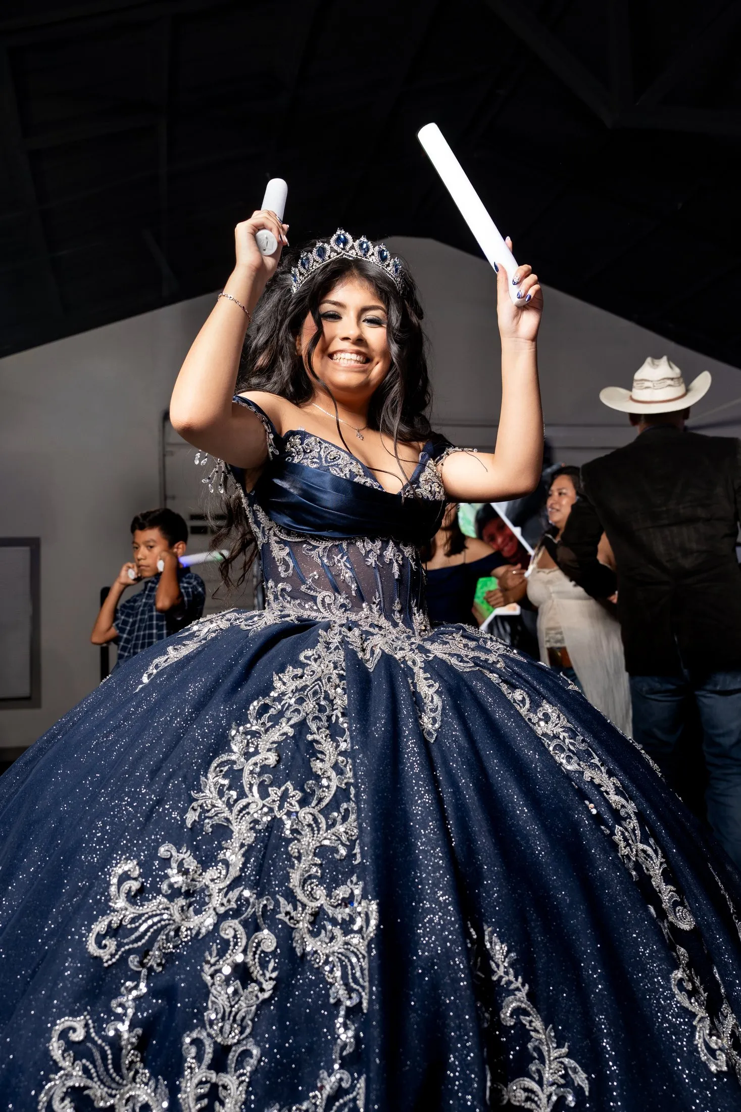 Joyful quinceañera dancing in her navy quince gown