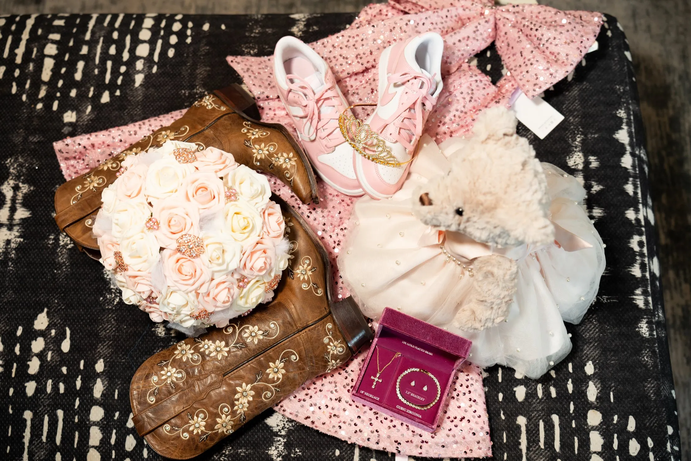 Quince details: embroidered cowgirl boots, pink sneakers, bouquet, teddy bear and ring box at Hidden Acres Ranch in Hudson Oaks
