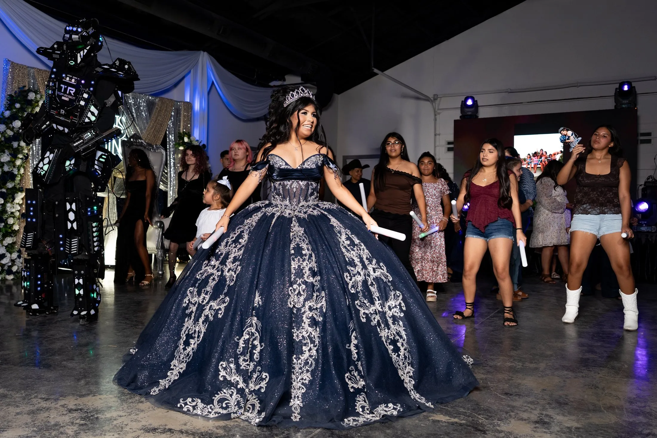Quinceañera and guests dancing with an LED robot during the hora loca