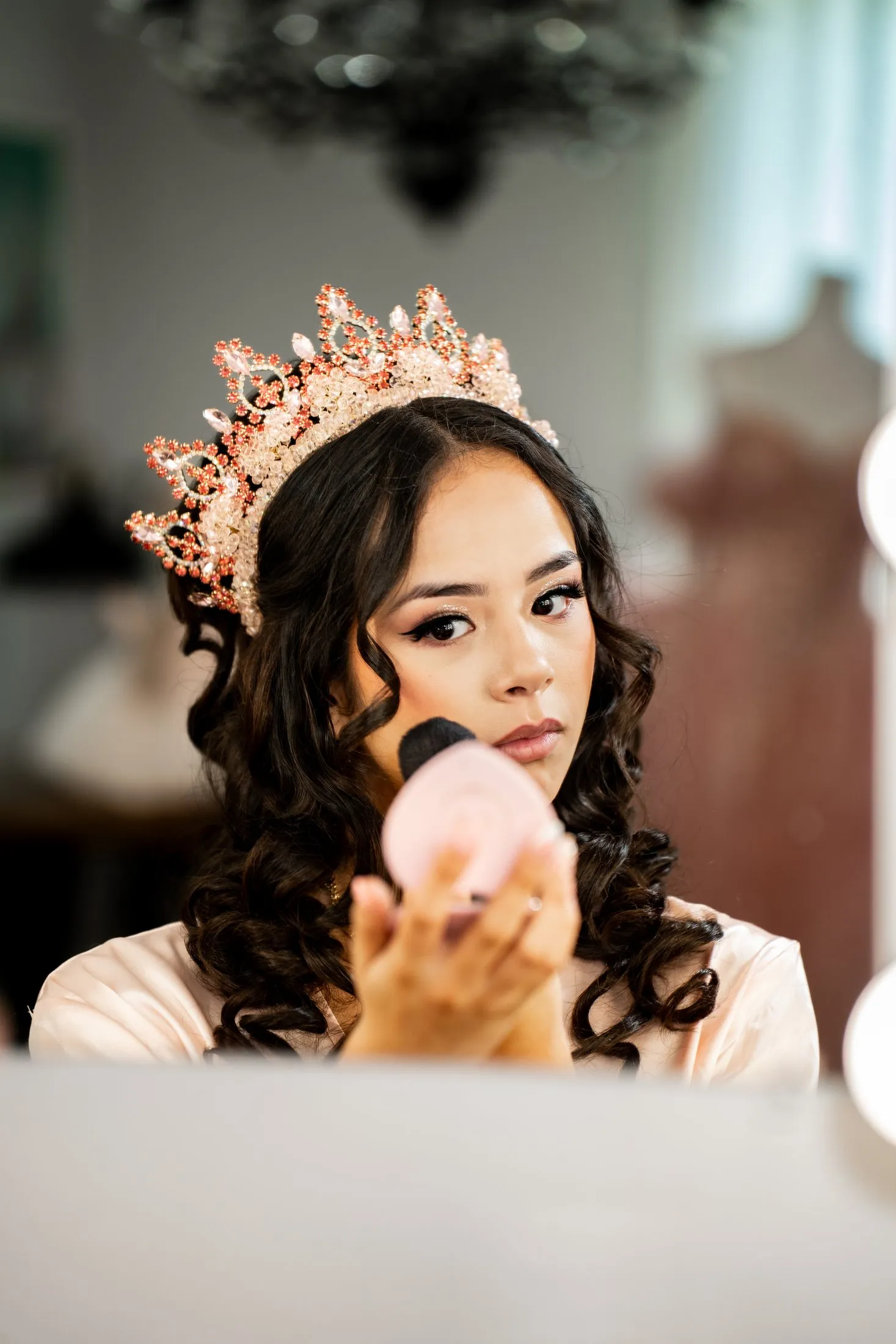Rosalie touching up her makeup in her rose-gold crown while getting ready at Hidden Acres Ranch in Hudson Oaks