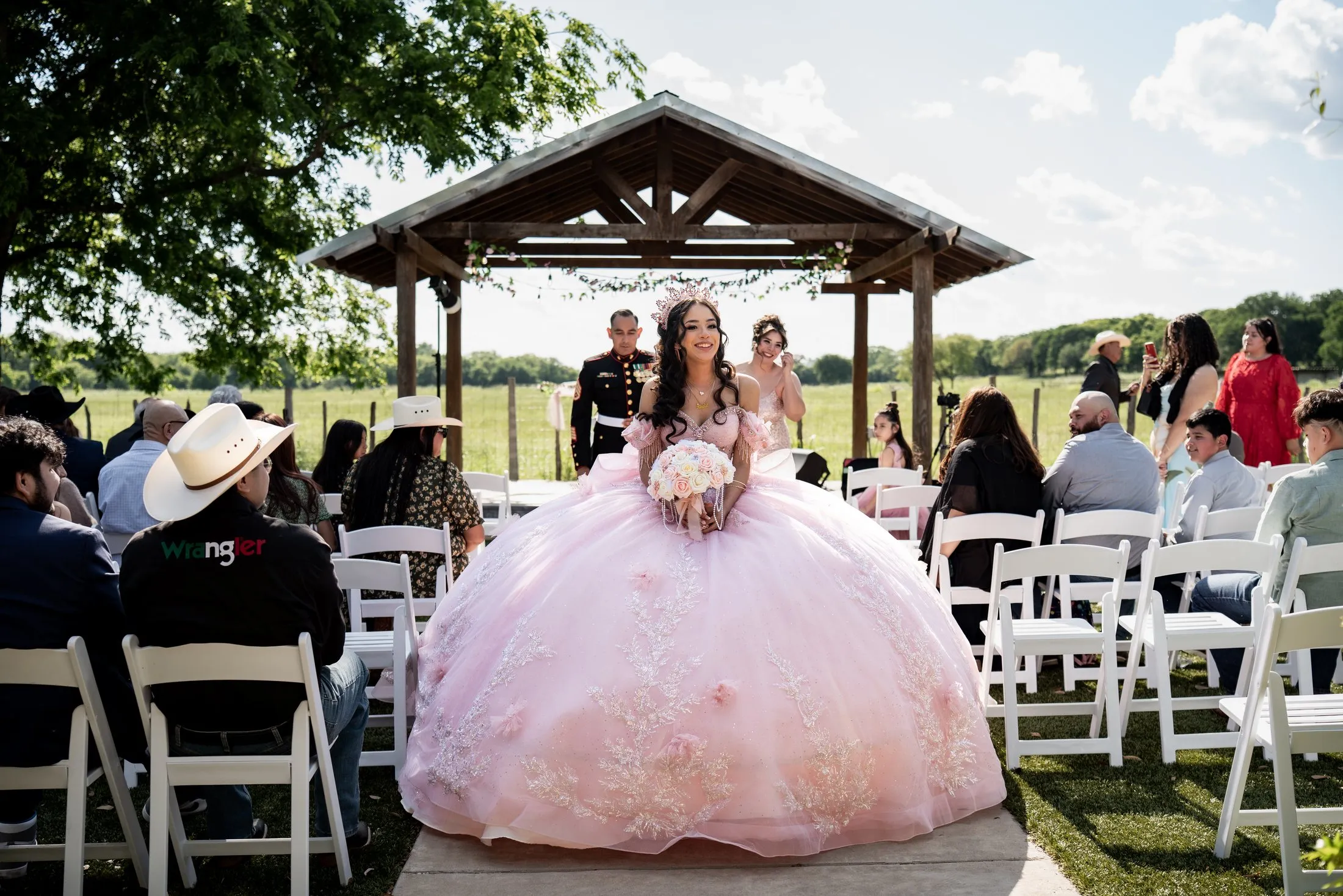 Quinceañera seated before her guests at the outdoor ceremony on a Texas ranch at Hidden Acres Ranch in Hudson Oaks