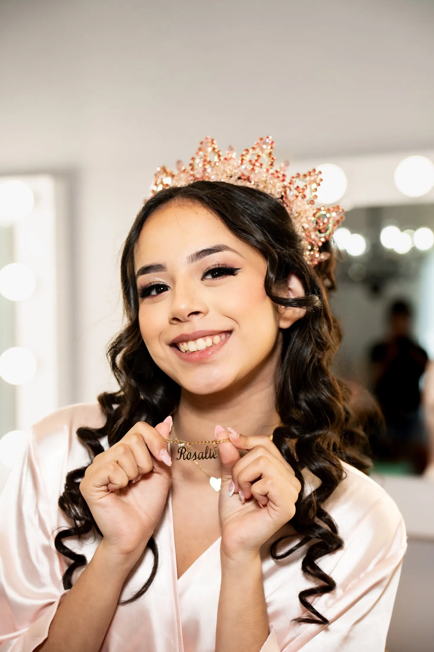Quinceañera smiling and showing her name necklace at Hidden Acres Ranch in Hudson Oaks