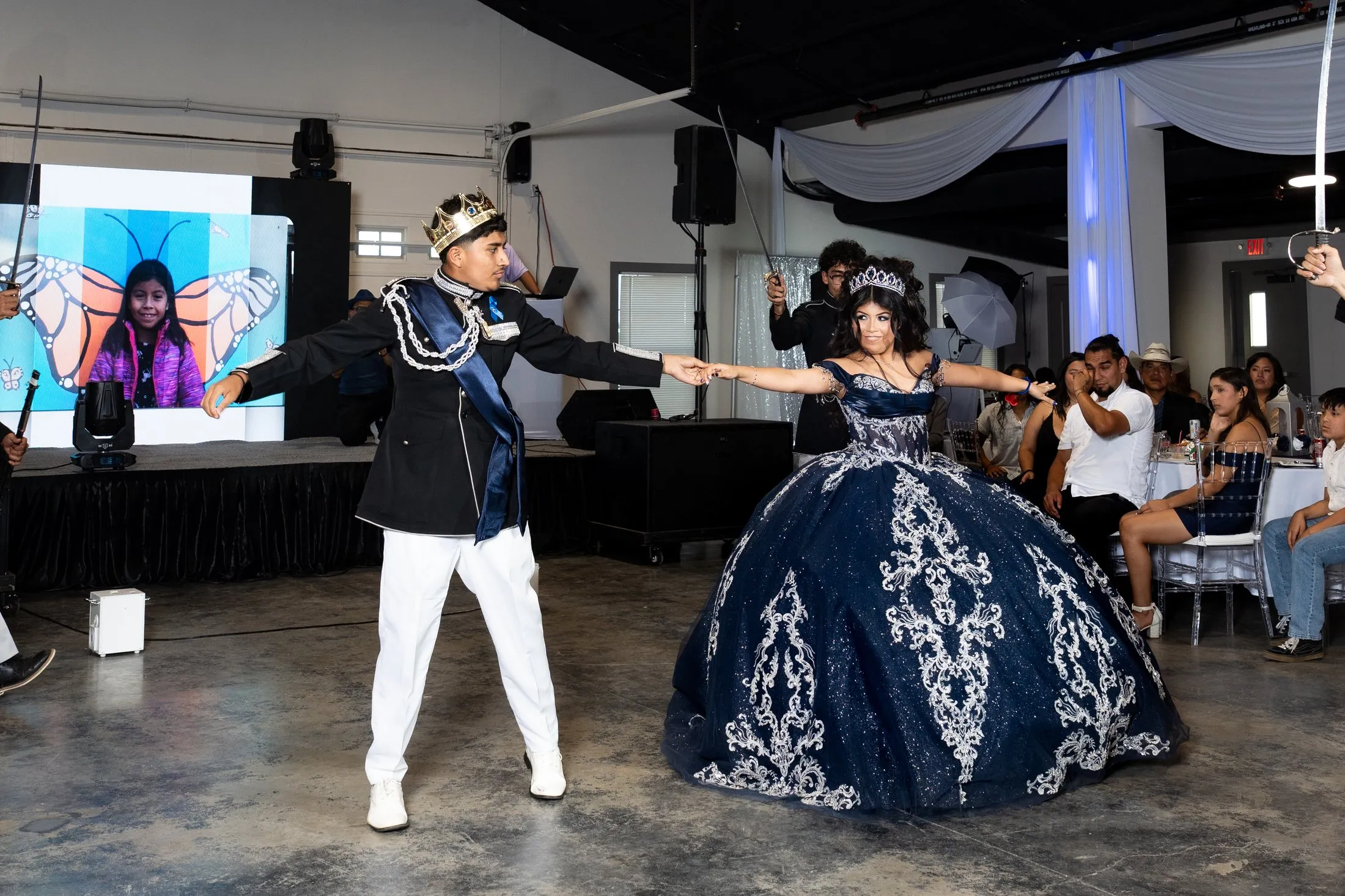 Quinceañera dancing the vals with her chambelán in a crown