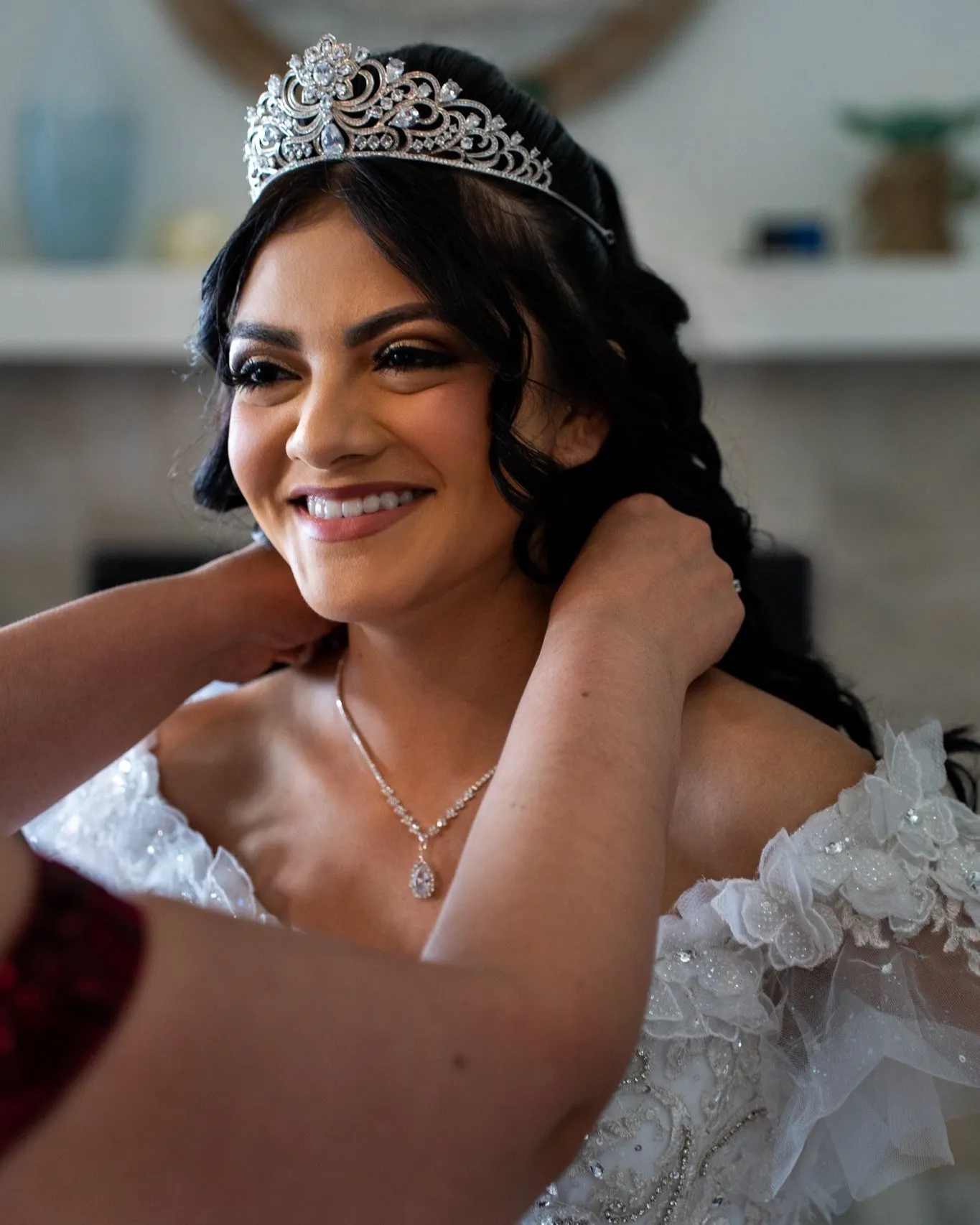 Mamá ayudando a su hija a arreglarse durante la preparación del día del quince